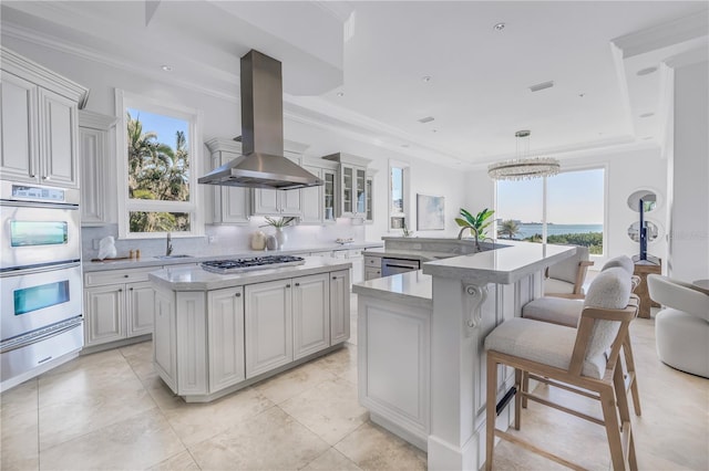 3935 N Shell Rd, Sarasota, FL 34242 - kitchen with appliances with stainless steel finishes, island exhaust hood, a center island, a warming drawer, and healthy amount of natural light