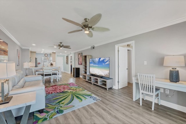 living room with baseboards, ceiling fan, wood finished floors, and crown molding