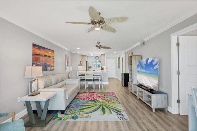 living area with light wood-style flooring, visible vents, and crown molding