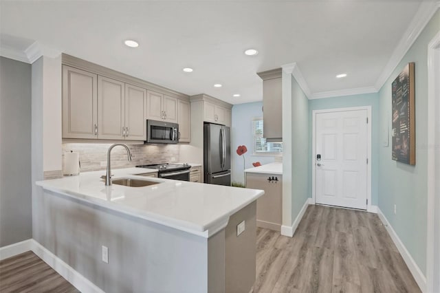 kitchen featuring stainless steel appliances, a peninsula, and light countertops