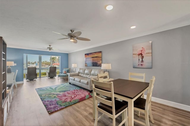 living room with ceiling fan, crown molding, baseboards, and wood finished floors