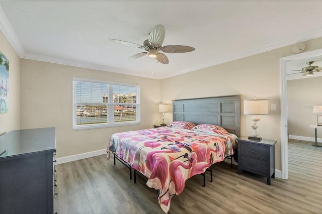 bedroom with ornamental molding, light wood-style flooring, and baseboards