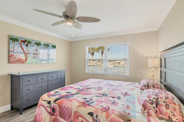 bedroom with light wood finished floors, a ceiling fan, baseboards, and crown molding