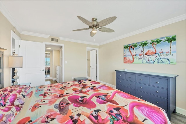 bedroom with crown molding, visible vents, a ceiling fan, wood finished floors, and baseboards