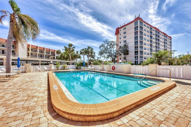 pool with a patio and fence