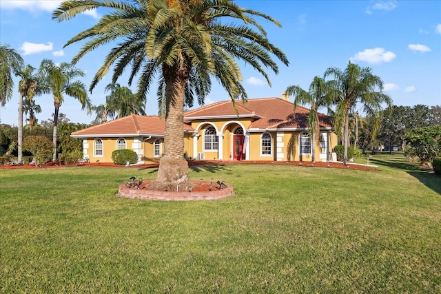 mediterranean / spanish-style house with a tiled roof, a front lawn, and stucco siding