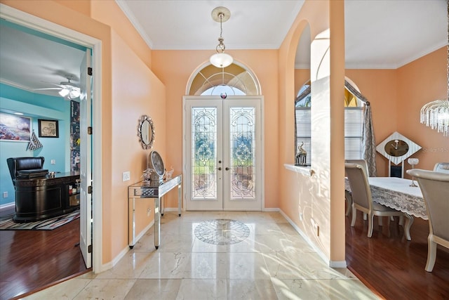 entryway with french doors, ornamental molding, wood finished floors, and baseboards