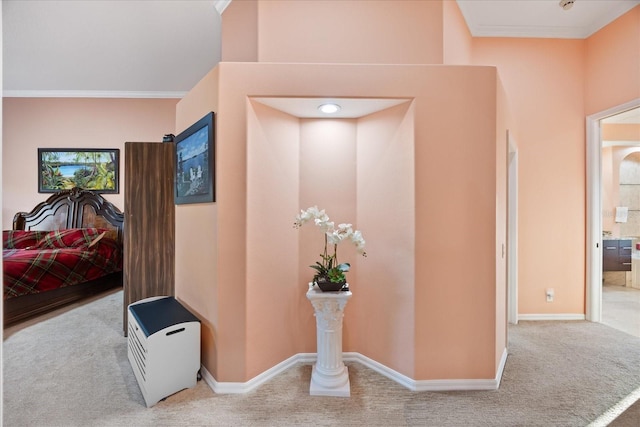 hall featuring carpet floors, baseboards, and ornamental molding