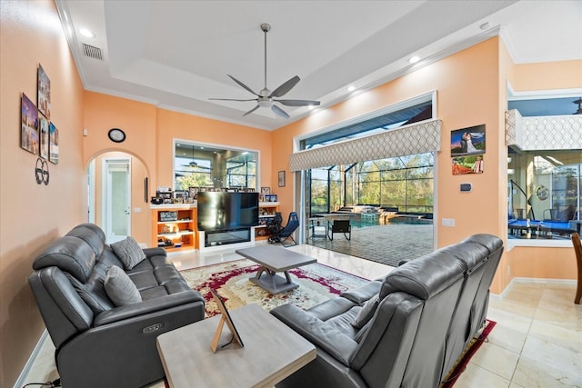 living room with arched walkways, a raised ceiling, a sunroom, ceiling fan, and recessed lighting