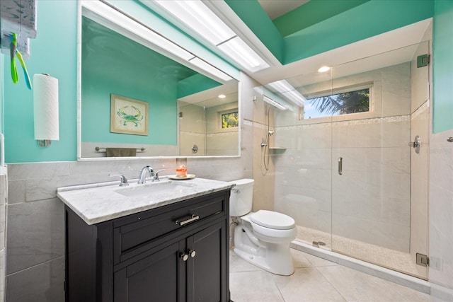 full bathroom featuring toilet, vanity, a shower stall, and tile walls