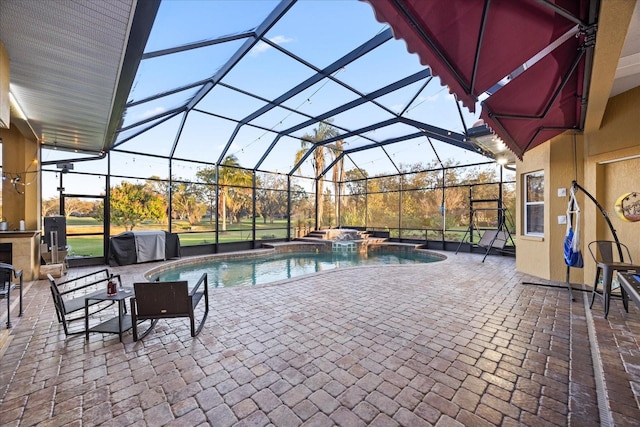 view of swimming pool with a patio, a grill, a pool with connected hot tub, and a lanai