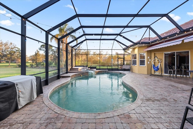 view of pool with a lanai, a pool with connected hot tub, and a patio