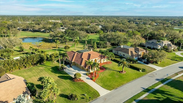 birds eye view of property featuring a water view and a wooded view