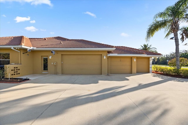 view of front of home featuring a garage, a tiled roof, and stucco siding