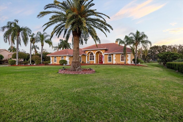 mediterranean / spanish-style home with a front yard and stucco siding