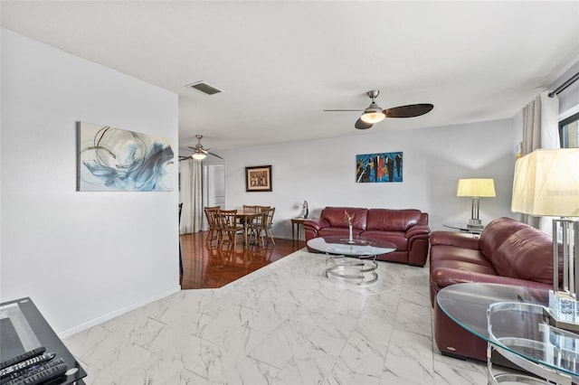 living room featuring marble finish floor, a ceiling fan, visible vents, and baseboards