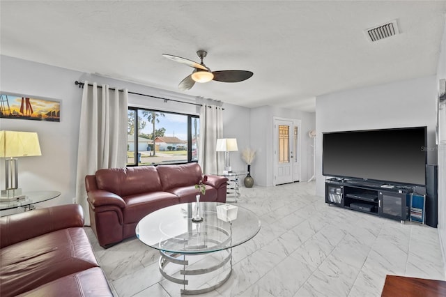 living room featuring ceiling fan, marble finish floor, a textured ceiling, and visible vents