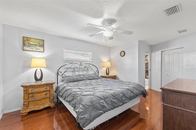 bedroom featuring visible vents, ceiling fan, baseboards, and wood finished floors