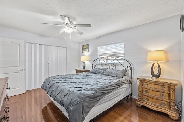 bedroom with ceiling fan, a textured ceiling, a closet, and wood finished floors