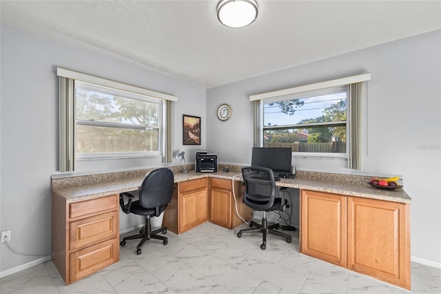 office area featuring marble finish floor, a wealth of natural light, and baseboards