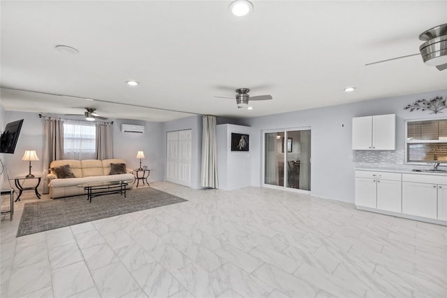 living room with ceiling fan, marble finish floor, and a wall mounted AC