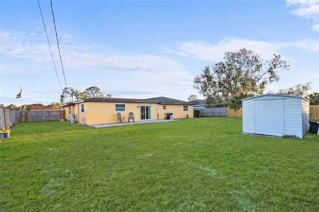 back of house featuring an outbuilding, a fenced backyard, a lawn, and a storage shed