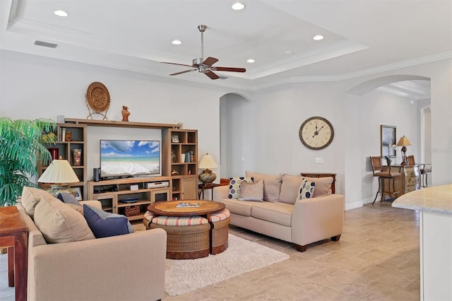 living area featuring visible vents, arched walkways, a raised ceiling, ornamental molding, and recessed lighting