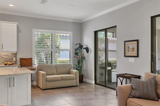 living area featuring baseboards, visible vents, crown molding, and recessed lighting