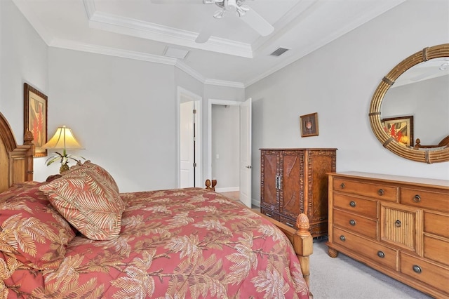 bedroom featuring light carpet, a tray ceiling, ornamental molding, and visible vents