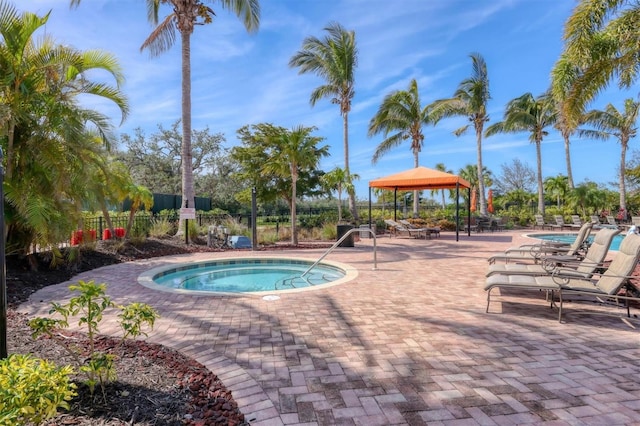 view of swimming pool with a community hot tub, a patio area, fence, and a gazebo