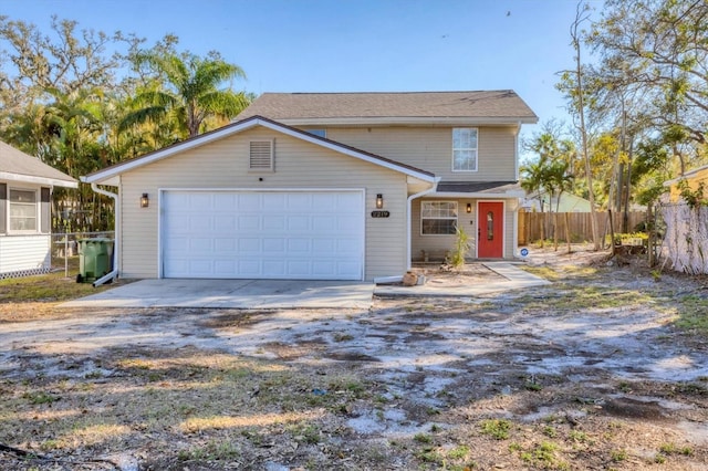 view of front of house featuring concrete driveway, an attached garage, and fence