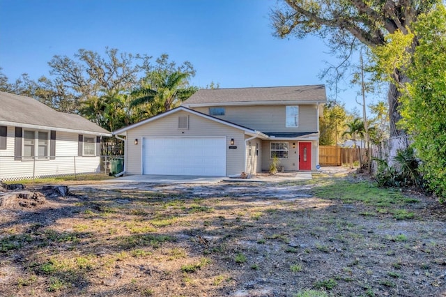 view of front facade with an attached garage, fence, and concrete driveway