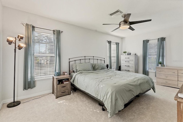 bedroom featuring baseboards, a ceiling fan, visible vents, and light colored carpet