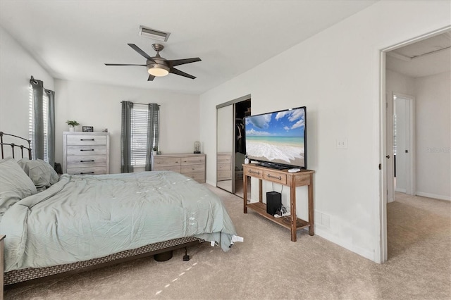 carpeted bedroom with a ceiling fan, visible vents, and a closet