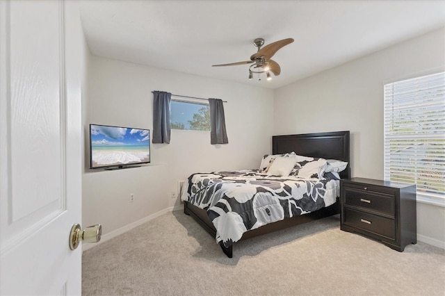 bedroom featuring baseboards, ceiling fan, and light colored carpet