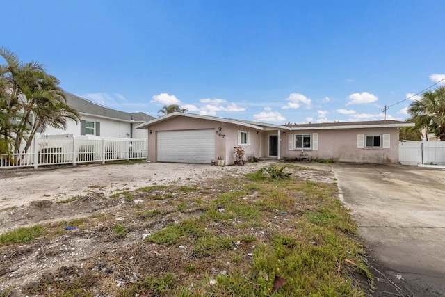 single story home with driveway, an attached garage, fence, and stucco siding