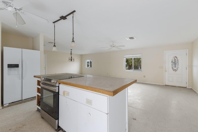 kitchen featuring pendant lighting, white cabinets, a kitchen island, white fridge with ice dispenser, and stainless steel range with electric stovetop