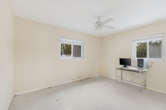 unfurnished office with baseboards and a ceiling fan