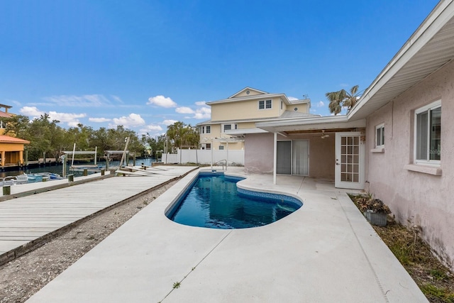 view of pool with a fenced in pool, a patio area, fence, and a boat dock