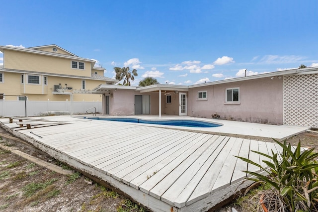 back of house featuring a fenced in pool, a patio area, fence, and stucco siding