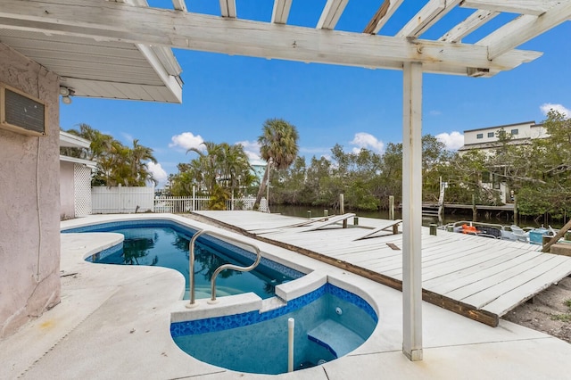 view of swimming pool featuring a patio, fence, a pool with connected hot tub, and a pergola