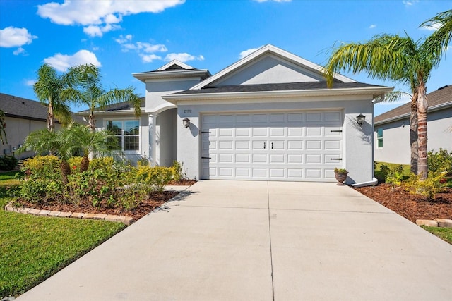 view of front of house featuring driveway, a garage, and stucco siding