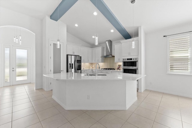 kitchen with stainless steel appliances, light countertops, white cabinetry, a sink, and wall chimney exhaust hood