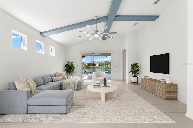 living room with arched walkways, light tile patterned flooring, visible vents, a ceiling fan, and beamed ceiling