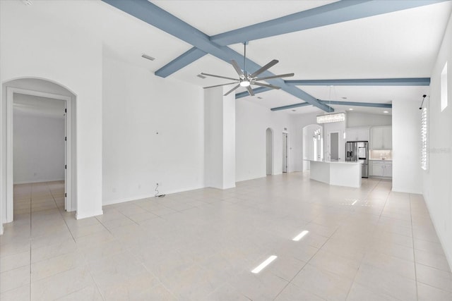 unfurnished living room featuring arched walkways, light tile patterned floors, vaulted ceiling with beams, visible vents, and a ceiling fan