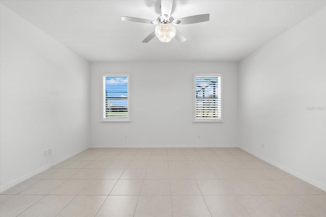 spare room featuring ceiling fan and baseboards