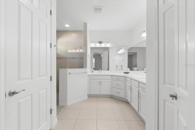 full bath with double vanity, visible vents, a sink, a walk in shower, and tile patterned flooring