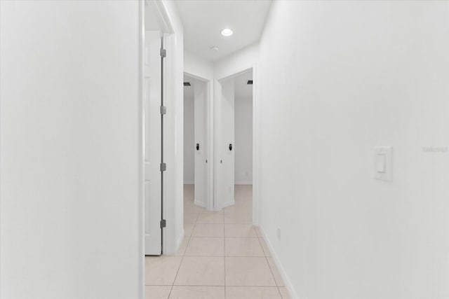 hall with recessed lighting, light tile patterned flooring, and baseboards