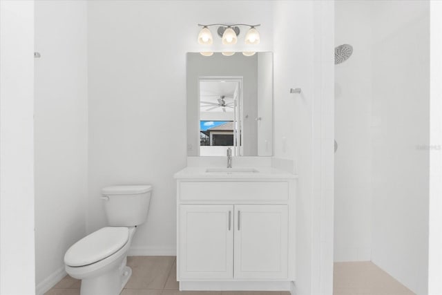 bathroom with toilet, a tile shower, vanity, baseboards, and tile patterned floors