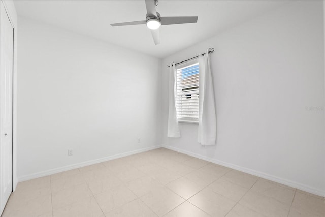 empty room featuring ceiling fan and baseboards